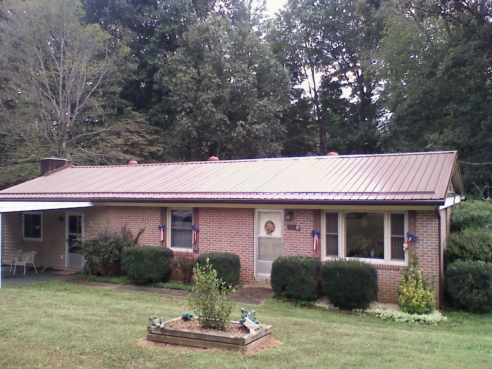 Bronze metal roof on a brick ranch home with a carport in Columbia